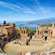 Ruinas de un anfiteatro, un volcán nevado y el mar